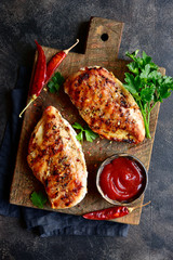 Grilled spicy chicken breast with ketchup.Top view with copy space. © lilechka75