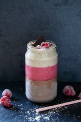 Layered smoothie with cocoa, raspberry and banana with almond milk
