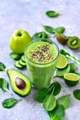 Detox green smoothie with green vegetables, oats and seeds in a tall glass.Top view with copy space.