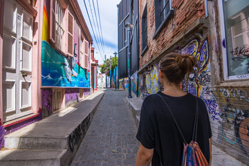 Frau in bunter Gasse mit Graffiti / Urban Art