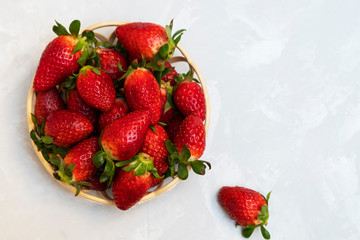 Strawberries in a basket on neural background. Image with copy space, top view