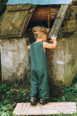 a boy with white hair in a green combination played at a well