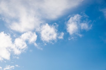 Naklejka na ściany i meble Fluffy white small clouds on the clear blue color sky background