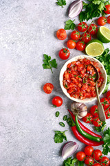 Tomato salsa (salsa roja) - traditional mexican sauce  with ingredients for making on a light grey...