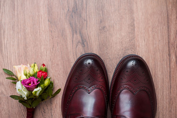 Close up of modern man accessories. Black bowtie, leather shoes, belt and flower boutonniere on white wood rustic background. Set for formal style of wearing isolated on white background.