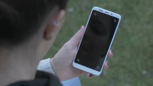Woman looking at blank, trackable phone screen, panning shot