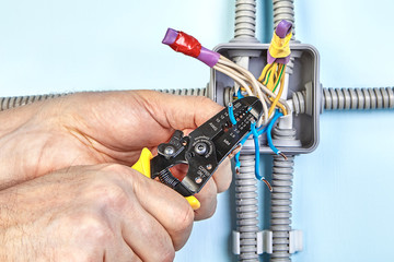 Worker removes insulation from wires.