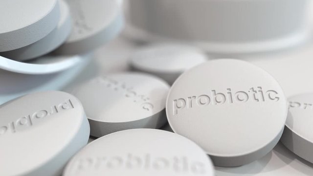 Close-up shot of pills with stamped PROBIOTIC text on them. 3D animation