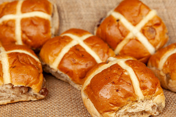 Freshly baked hot cross buns on a brown muslin cloth