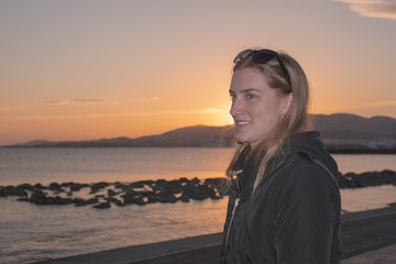Fototapeta premium Young beautiful woman with classical natural look in profile at sunset