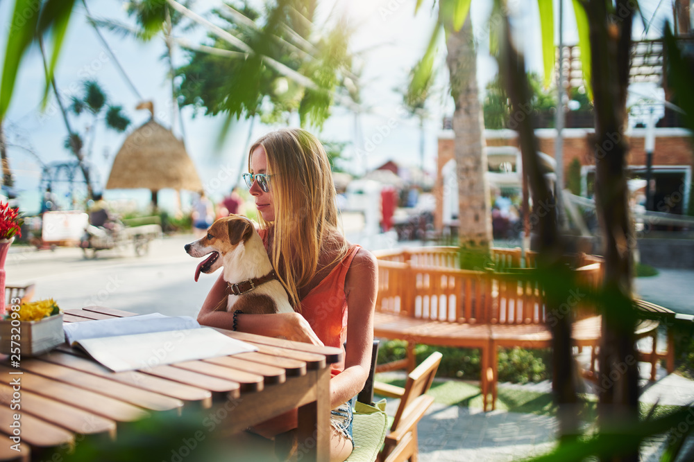 Wall mural female russian tourist sitting at thai cafe with pet dog