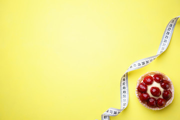 healthy lifestyle, dieting, weight loss, balanced food. delicious sweet berry cake and measure tape. diet and fitness blog design concept