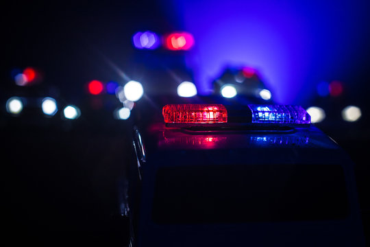 Police cars at night. Police car chasing a car at night with fog background. 911 Emergency response pSelective focus