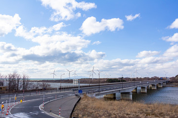 風力発電と道路を走行する自動車　自然エネルギー　イメージ