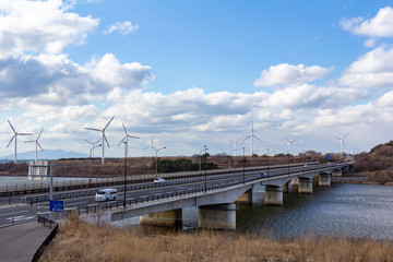 風力発電と道路を走行する自動車　自然エネルギー　イメージ