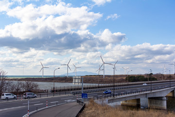 Obraz premium 風力発電と道路を走行する自動車 自然エネルギー イメージ