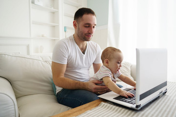 Happy family using laptop and having fun. Father and son watching video or playing game together. Parenting, childhood, technology and people concept