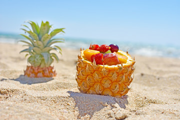 Summer relax with mix fruit in pineapple bowl on beach