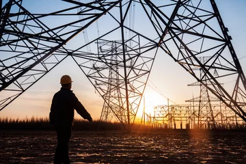 Foto op Aluminium electricity workers and pylon silhouette © zhengzaishanchu