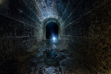 Dark and creepy old historical vaulted flooded underground drainage tunnel - obrazy, fototapety, plakaty