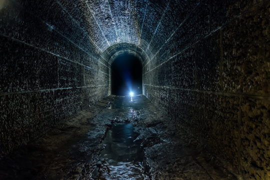 Fototapeta Dark and creepy old historical vaulted flooded underground drainage tunnel