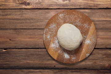 Dough on a round cutting board. Top view.