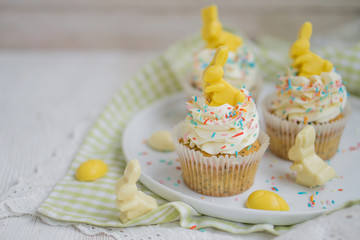 Lemon poppy seed cupcake with easter chocolate bunny and eggs close up selective focus