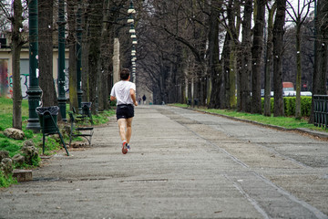 Fototapeta premium Man jogging outdoors in public park, running for health.