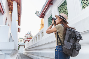 Asian woman travel Bangkok, Thailand, in beautiful temple during summer season, taking photo by...