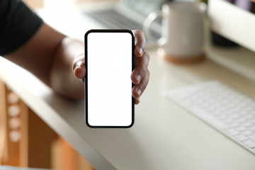 Man showing blank screen mobile phone at office