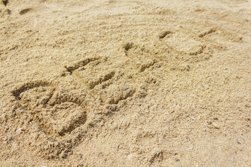 Fototapeta na wymiar Beach word written on the sand at the beach, natural background