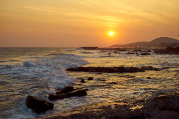 Obraz premium Sunset on the seashore of Vietnam. orange colour of the sky, Hills and people, who meet the evening. 