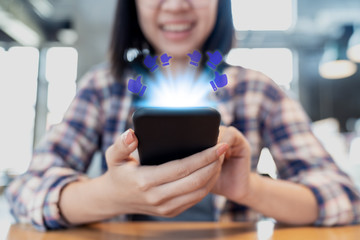 Young happy hipster asian woman using smartphone on table in cafe in social media concept. Lifestyle of millennials asian people with online shopping, ecommerce business using 5G connection on iot.