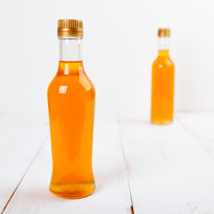Two glass bottles with homemade orange syrup