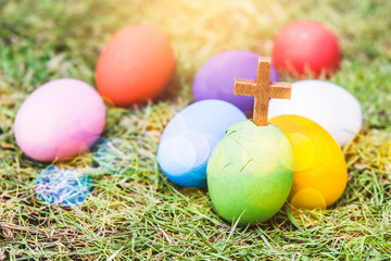 wooden cross in cracked  green egg   on green grass with wooden background, Easter background,copy space, concept