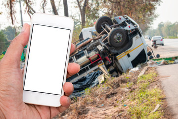 Truck accident. Truck lies on the road after incident. Blank smart phone.