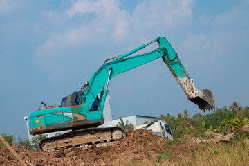 Obraz premium The blue-green excavator is working.