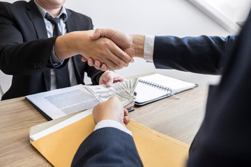 Dealing greeting and partnership meeting concept, businessmen handshaking after finishing up deal contract for both companies.
