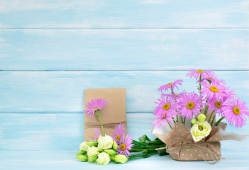 Chamomile and rose flowers and gift box on wooden background in Shabby Chic style