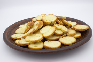 Bake Rolls. The mini bread chips on the brown bowl. Isolated on white background.