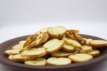 Bake Rolls. The mini bread chips on the brown bowl. Isolated on white background.