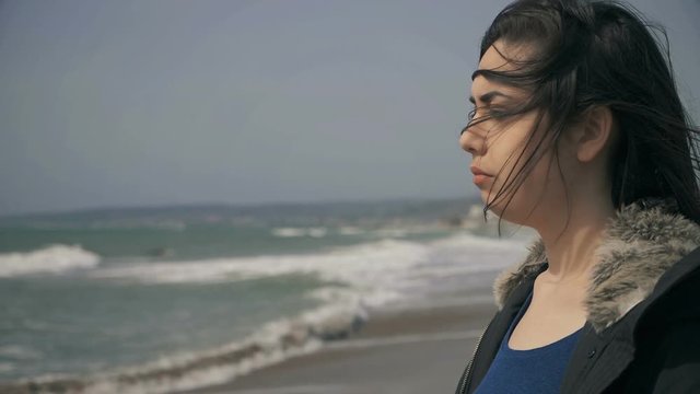 Lonely thoughtful young Woman Standing At The Beach, Looking At Sea-slow motion
