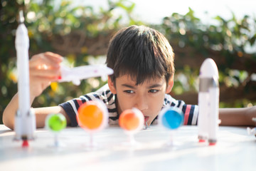 Little boy playing space ship and planet galaxy toy
