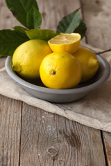 Lemon and half of lemon on brown background. Lemon on brown wooden table