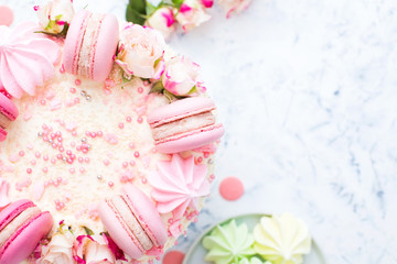 Fototapeta na wymiar Wedding white cake with macarons and roses, top view