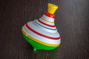 Multi-colored children's toy. Plastic whirligig on a black background. Close-up.