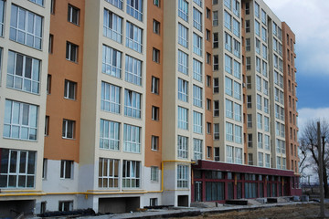 Fototapeta premium construction of a multi-storey building next to a built house