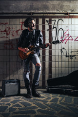 A street musician playing on guitar in the underpass. Vagrant lifestyle. Playing in the underpass...