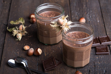 Chocolate pannacotta with nuts on black background.
