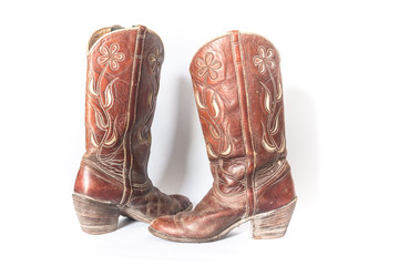 Old dirty cowboy boots on a white background